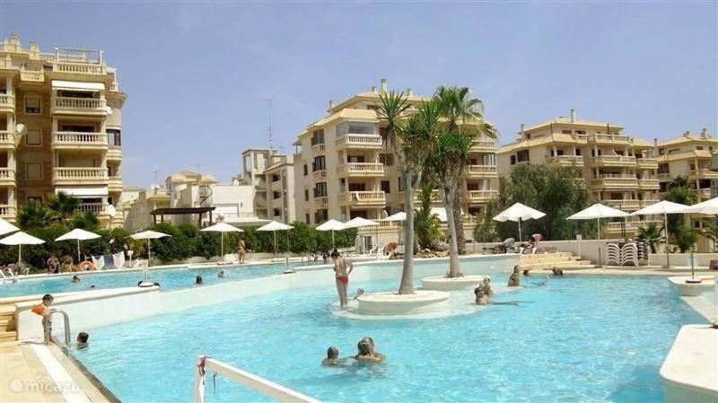 uma grande piscina com pessoas na água em Dream villa with sea views and swimming pool! em Guardamar del Segura