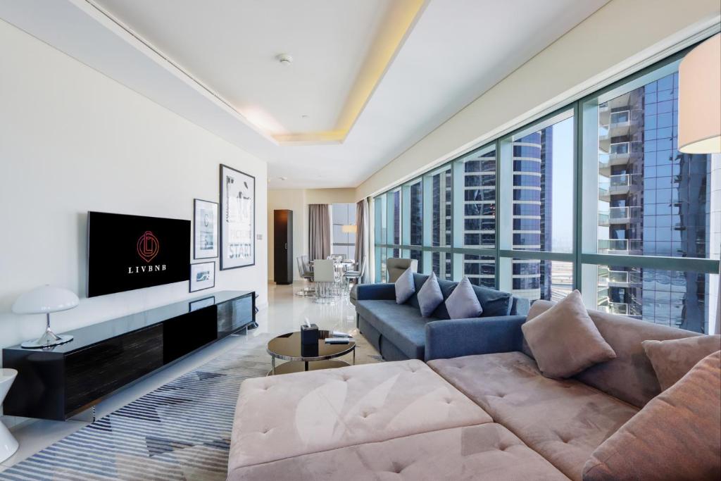 sala de estar con sofá y TV en 2BR Oasis in Damac Towers by Livbnb en Dubái