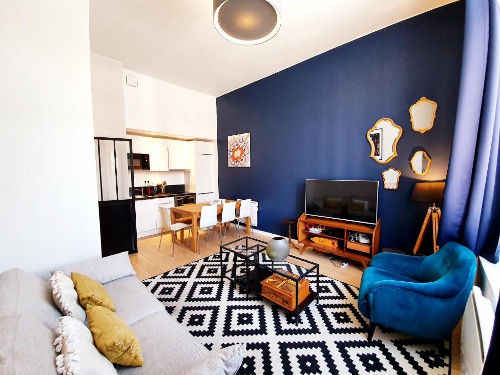 - un salon avec un canapé blanc et un mur bleu dans l'établissement Lille Centre Ville, Beaux Arts et Grand Palais, Bienvenue chez Nestyou Lille, à Lille