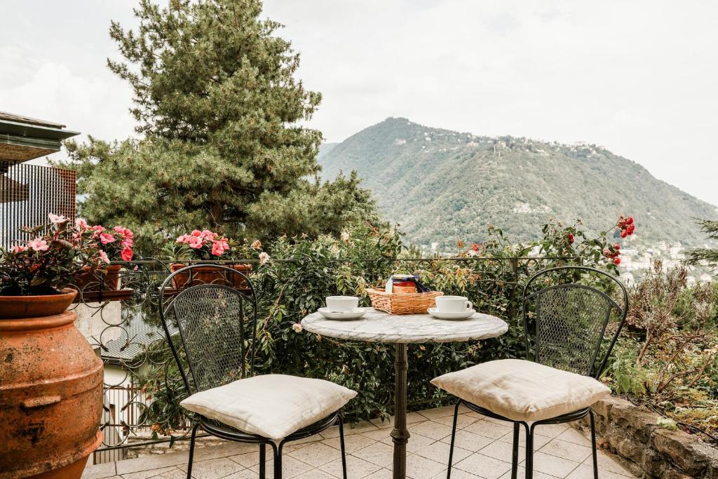 a table and chairs on a patio with a mountain at Casa Panoramica - by My Home In Como in Como
