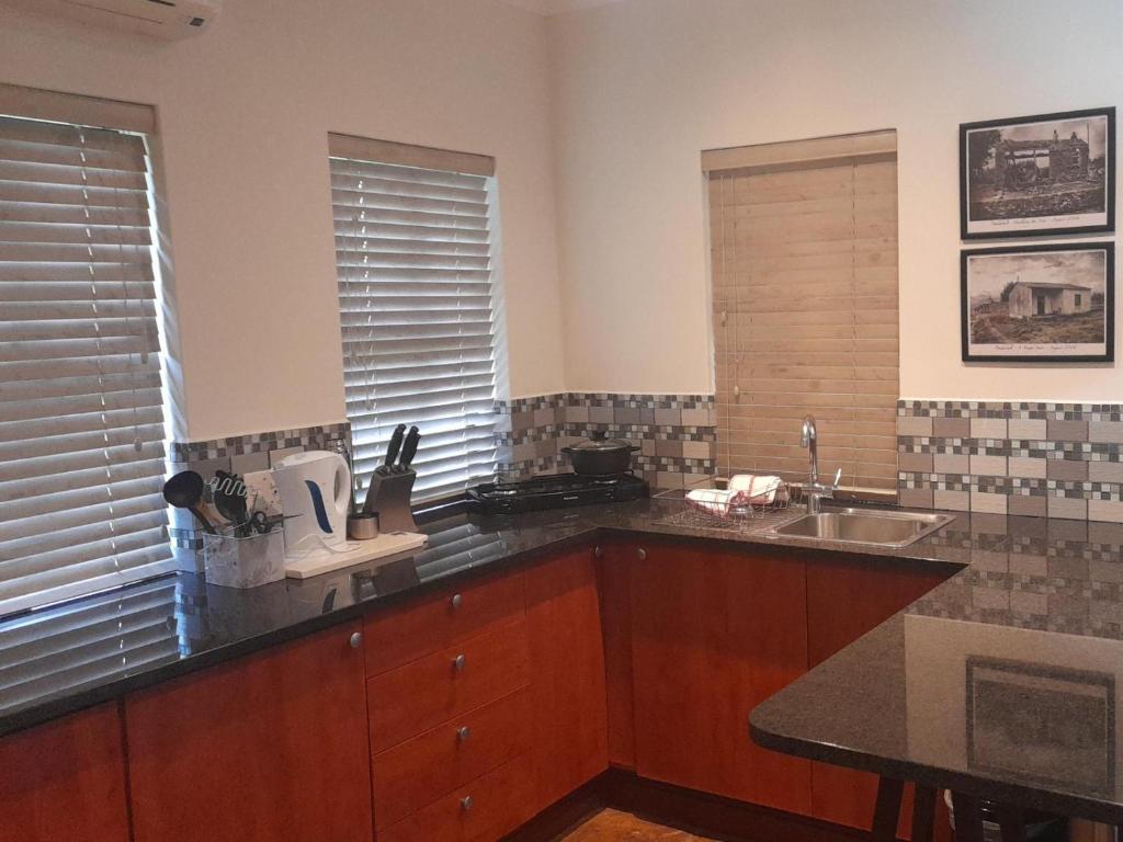 cocina con fregadero y encimera en Paddabult Self Catering Cottages, en Paarl