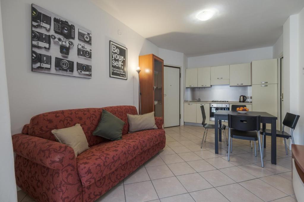 sala de estar con sofá rojo y cocina en Le Porte Blu, en Passirano