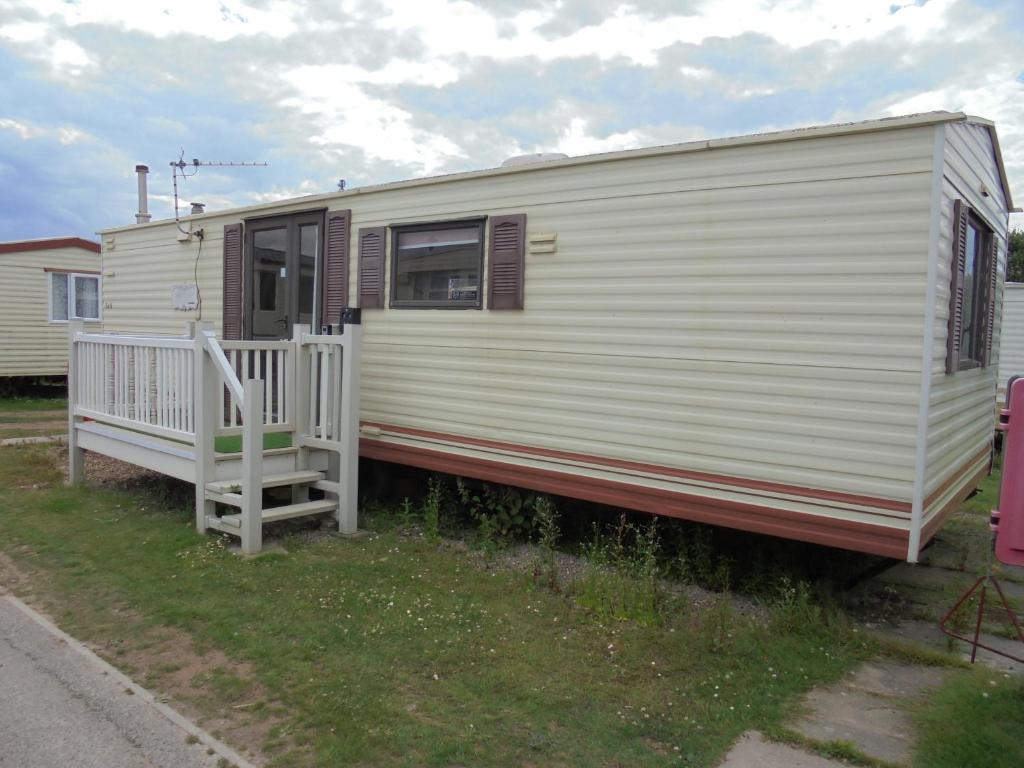 a white rv with a porch and a ramp at Promenade: Retreat:- 4 Berth, Access to the beach in Ingoldmells