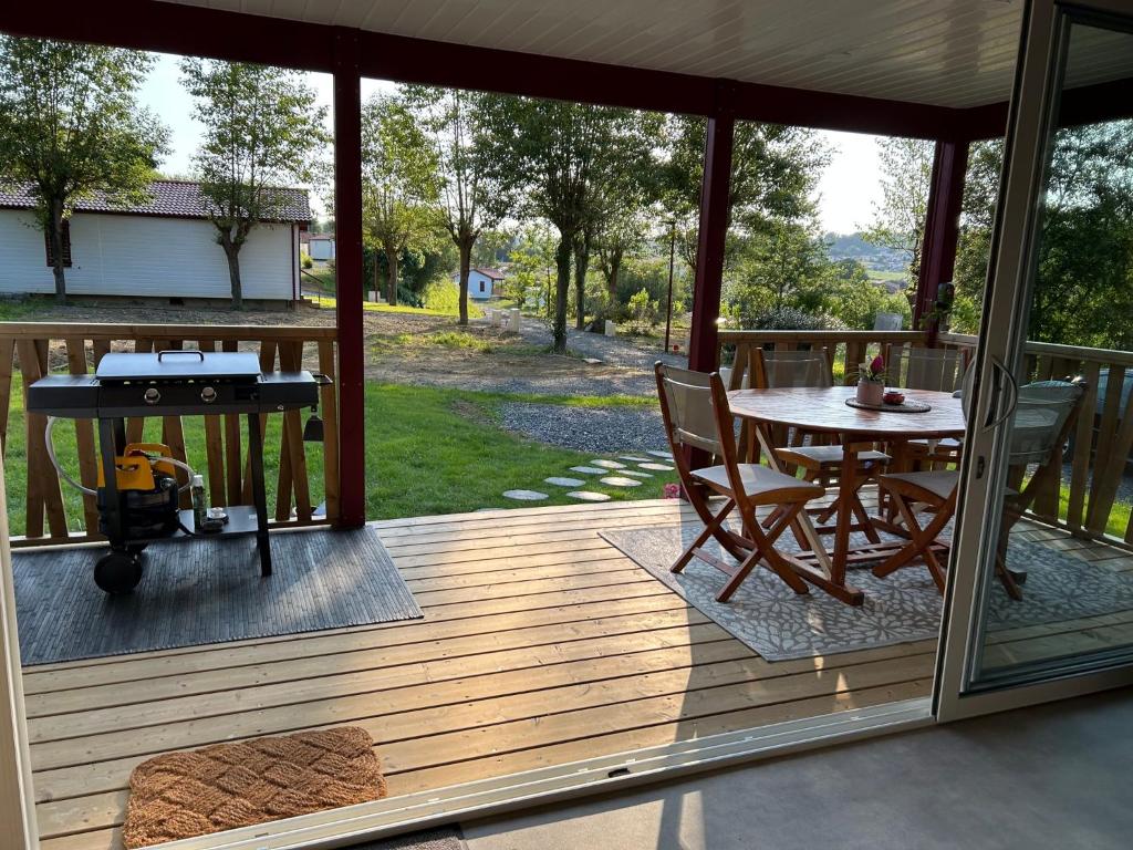 een afgeschermde veranda met een tafel en een grill bij Erreka pays basque in Hasparren