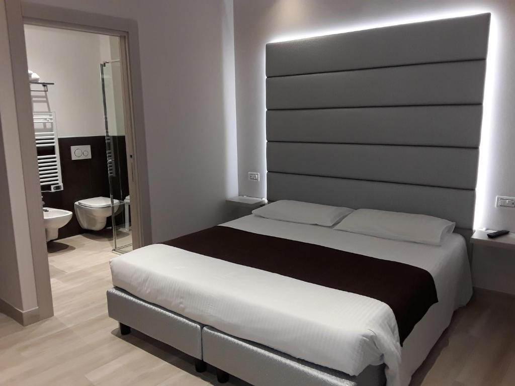 a bedroom with a large bed and a bathroom at Hotel Danieli La Castellana lago di Garda in Brenzone sul Garda