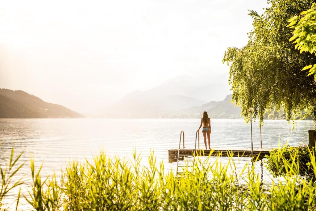 a woman standing on a dock in the water at Seefels Appartements in Döbriach
