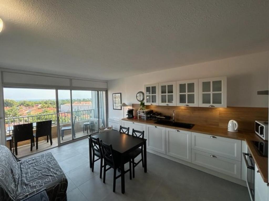 une cuisine et un salon avec une table et des chaises dans l'établissement Appartement T2 cabine avec parking sécurisé à 200m de la plage - FR-1-388-178, à Argelès-sur-Mer