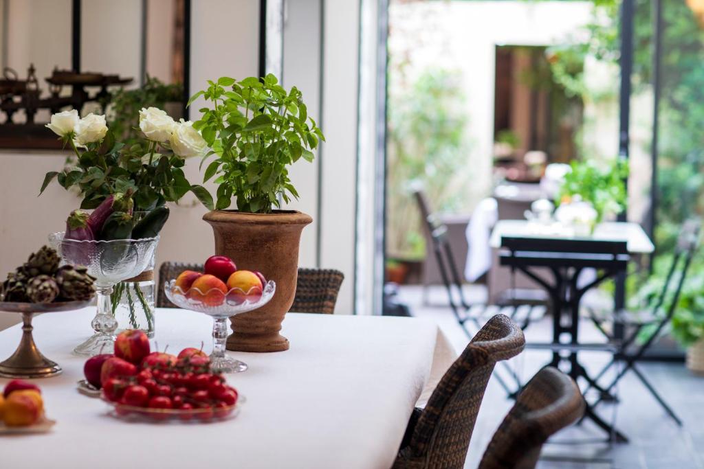 a table with a bowl of fruit and a vase of flowers at La Maison Bordeaux in Bordeaux