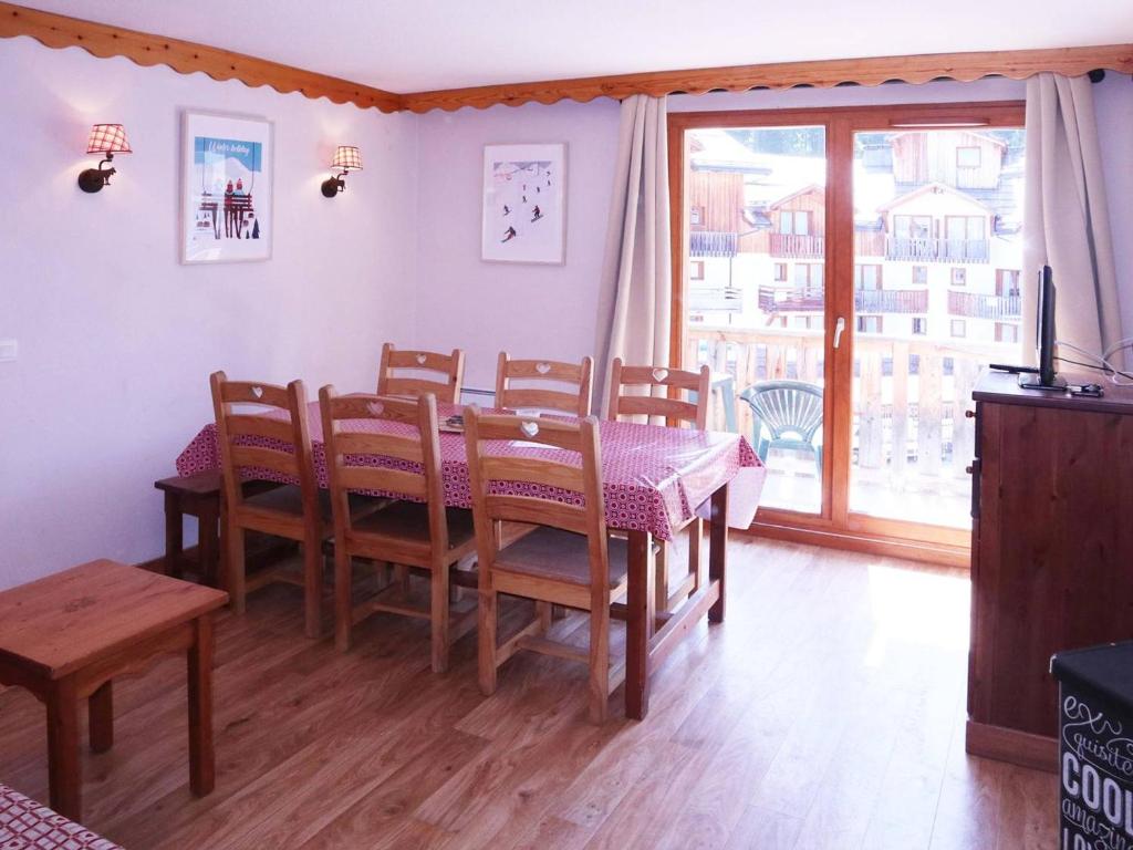 une salle à manger avec une table et des chaises et une fenêtre dans l'établissement Luxueux appart 3 chambres, piscine chauffée, sauna, ski aux pieds, wifi, animaux admis - FR-1-322-456, aux Orres