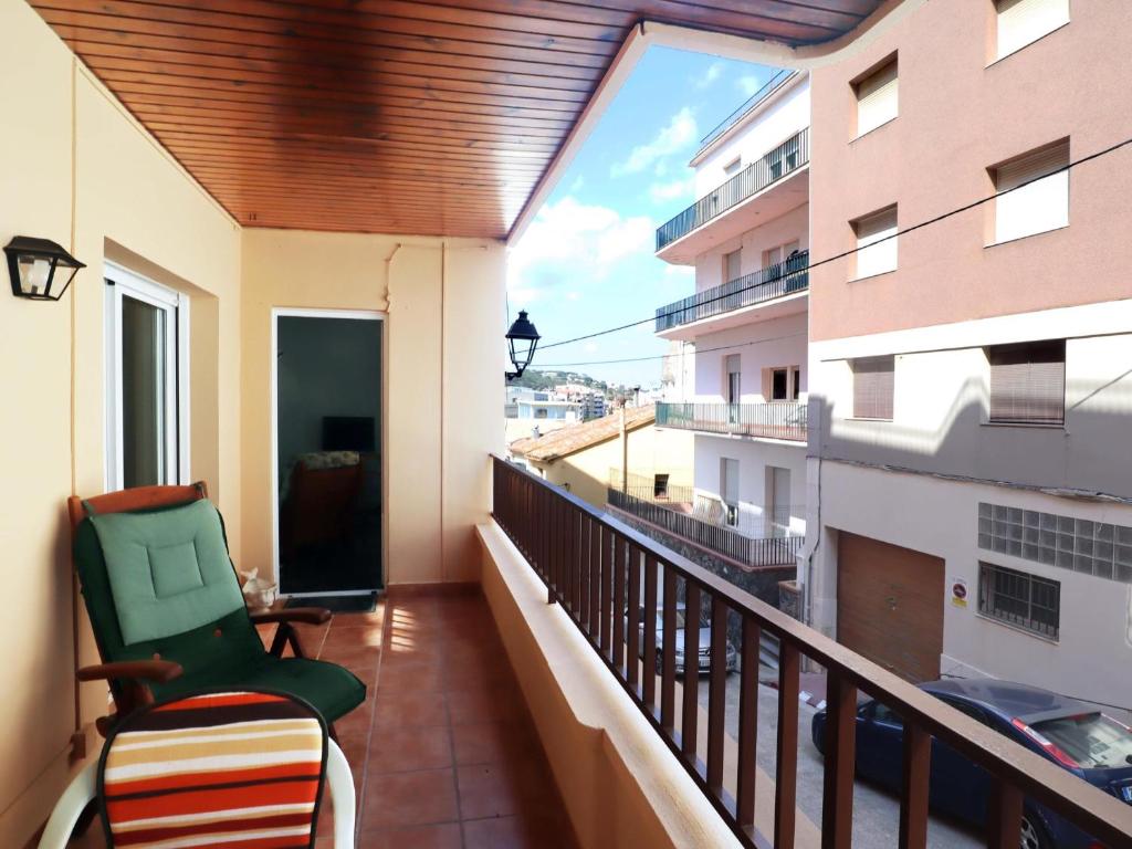 - Balcón con silla y vistas a un edificio en D16241 Sant Telm II, en Sant Feliu de Guíxols