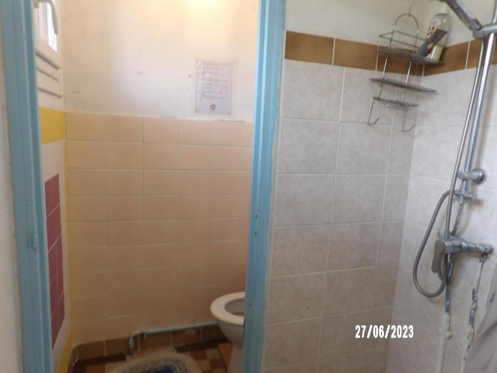 a bathroom with a toilet and a shower stall at Calme de la campagne in Le Torp-Mesnil