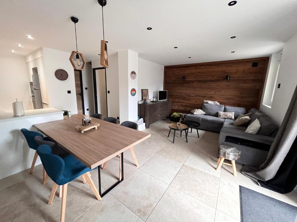 un salon avec une table et un canapé dans l'établissement Appartement en montagne 90m2 3 chambres, à La Chal