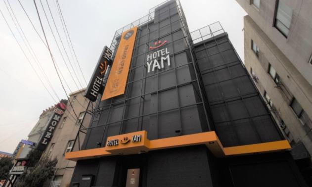 a building with a hotel sign on top of it at Hotel Yam - Paju Geumchon in Paju