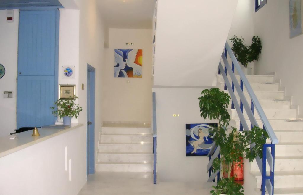 a hallway with white stairs and blue accents at Danae Hotel in Limenas