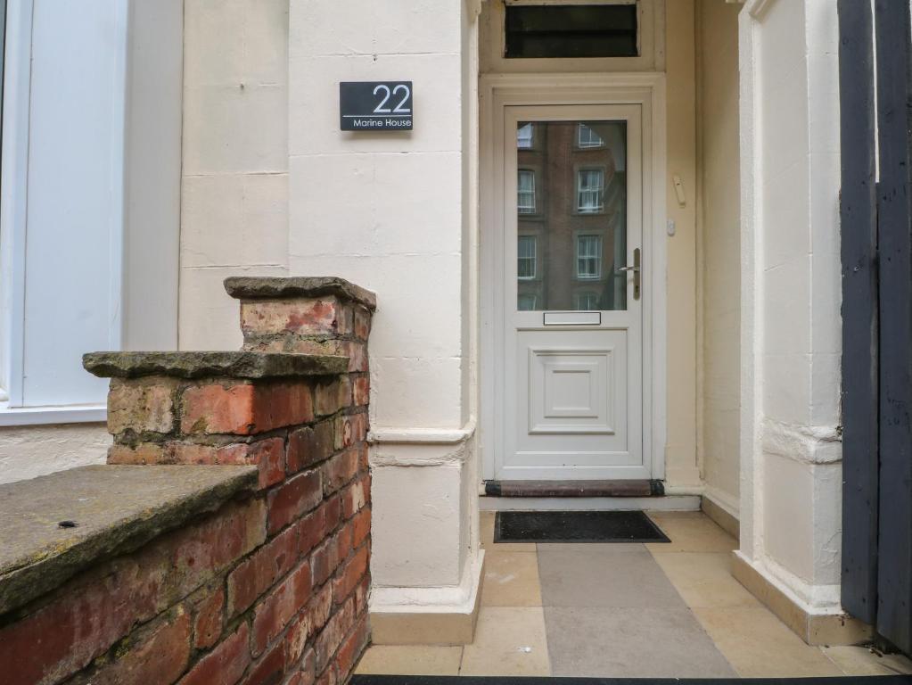 Una puerta de un edificio con un cartel en ella en Marine House, en Southport