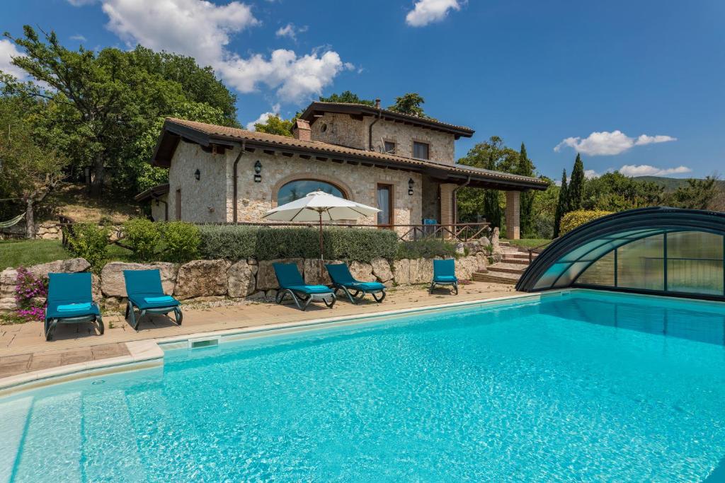 a villa with a swimming pool in front of a house at IL CASALE DEL NONNO 8&2 Emma Villas in Guardea