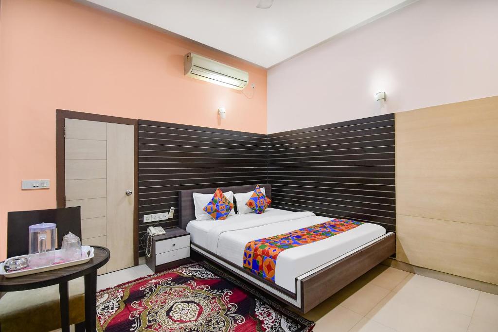 a bedroom with a large bed and a table at FabExpress Gardenia in Ballygunge