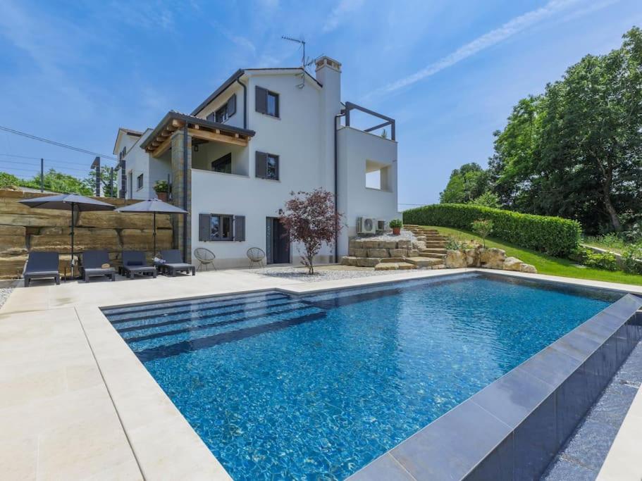 a villa with a swimming pool in front of a house at Rokvilla in Motovun