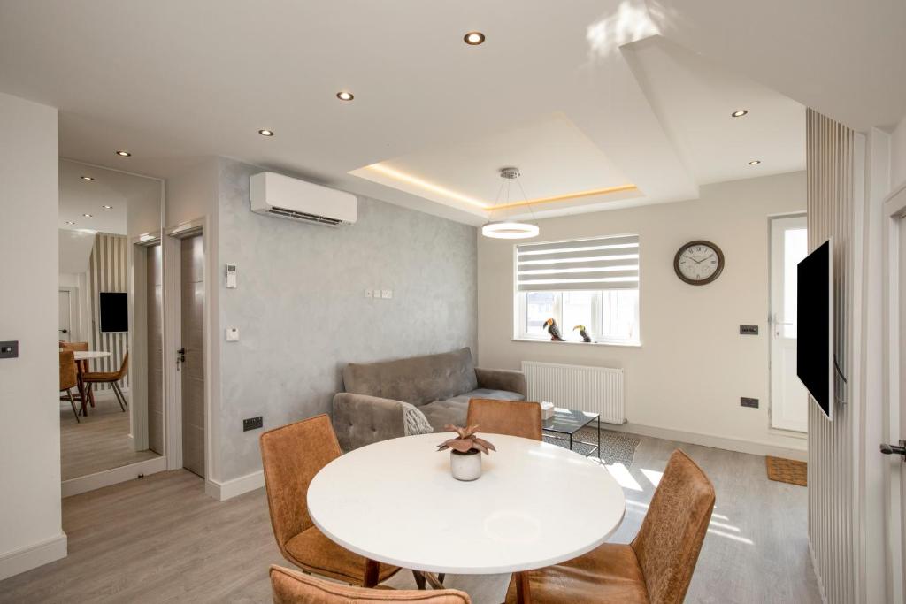 ein Wohnzimmer mit einem weißen Tisch und Stühlen in der Unterkunft Luxury spacious modern new apartment -fully equipped in London