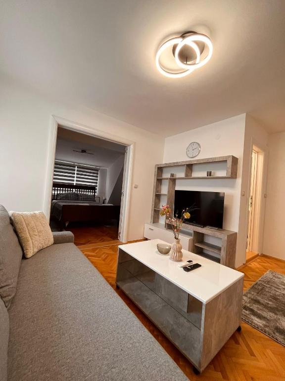 uma sala de estar com um sofá e uma mesa em Dekster apartmani em Valjevo