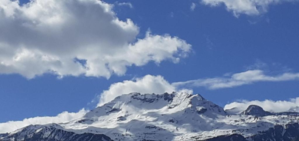 una montagna innevata con nuvole nel cielo di Casa Quokka a Meana di Susa
