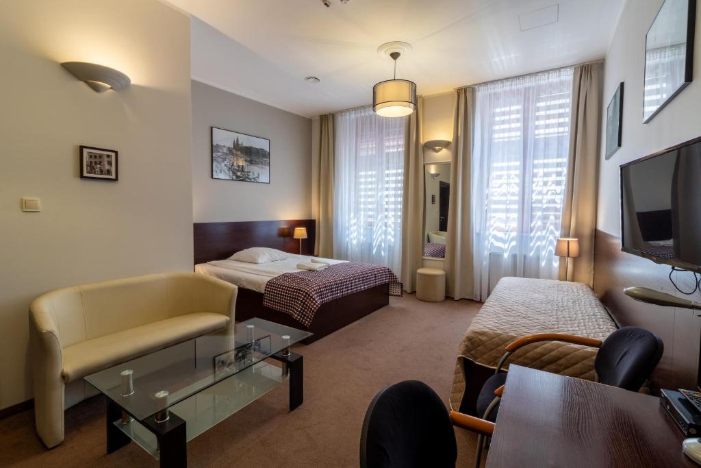 ein Hotelzimmer mit 2 Betten und einem TV in der Unterkunft Atlantic Aparthotel in Krakau