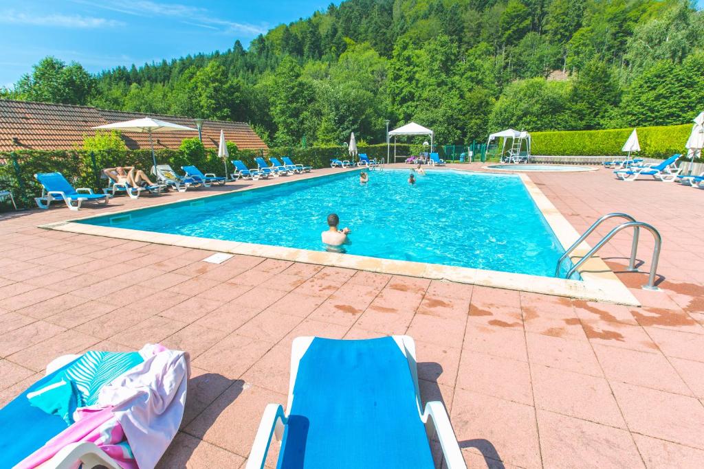 uma grande piscina com uma pessoa na água em VVF Les Fontaines des Vosges em Saales