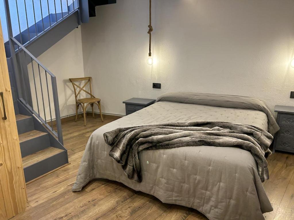 Un dormitorio con una cama con una manta. en Casa MARcerdanya, en Puigcerdà