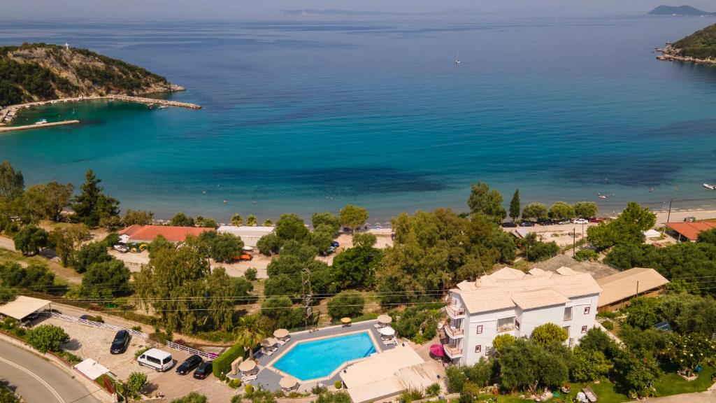 an aerial view of a house with a swimming pool and the ocean at hotelsunnybeachgr in Perdika