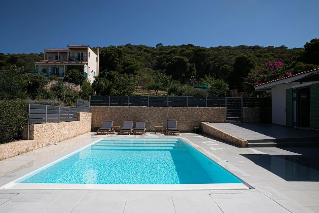 a swimming pool with chairs and a house at Pine House in Áyioi