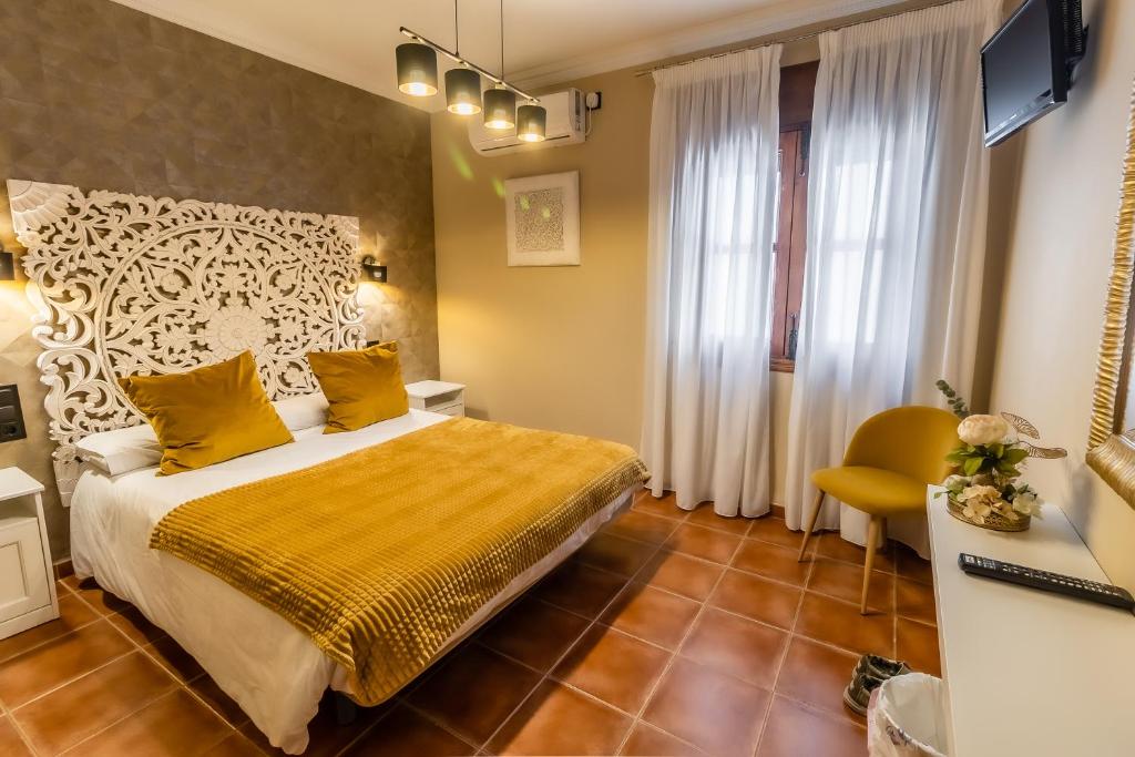 a hotel room with a bed and a yellow blanket at Hostal El Bomba 