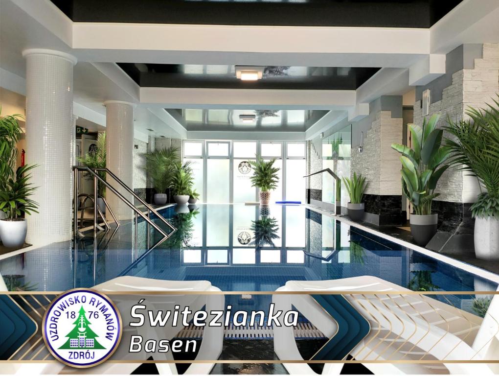 a hotel lobby with a swimming pool and plants at Świtezianka in Rymanów-Zdrój