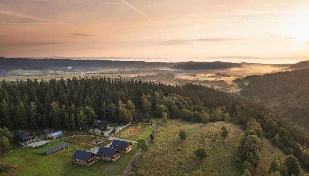 an aerial view of a house in the hills with a foggy valley at Domy wakacyjne Familia in Duszniki Zdrój