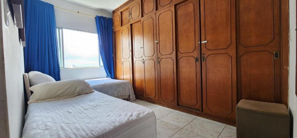 Dormitorio pequeño con cama y armarios de madera en Apartamento Vitória Vista ao Mar en Salvador