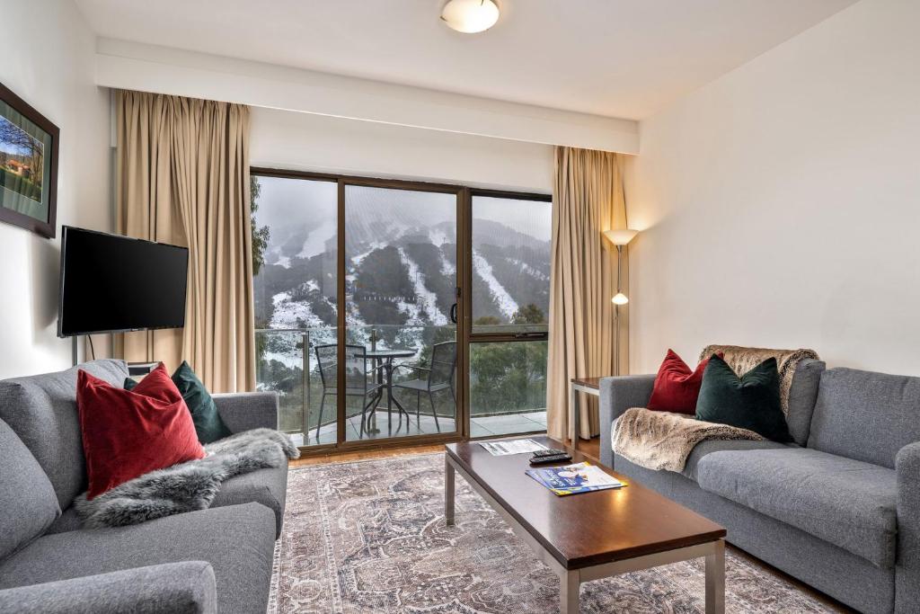 a living room with couches and a view of a mountain at Lantern 18 Balcony in Thredbo
