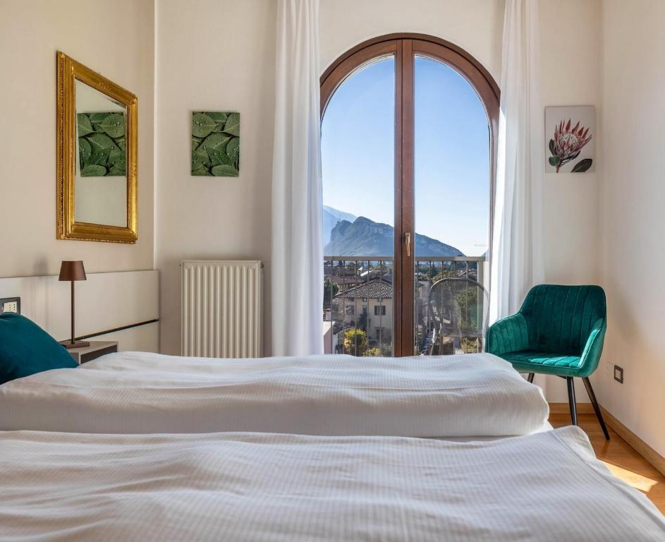 a bedroom with a bed and a large window at Appartamenti Villa Belvedere in Arco