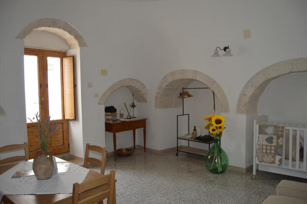 salon z łukami, stołem i krzesłami w obiekcie Trullo Pugliese w Alberobello