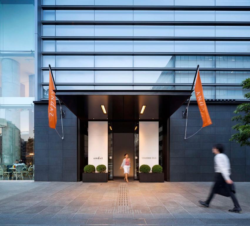 a man and a woman walking into a building at Andaz Tokyo - A Concept by Hyatt in Tokyo