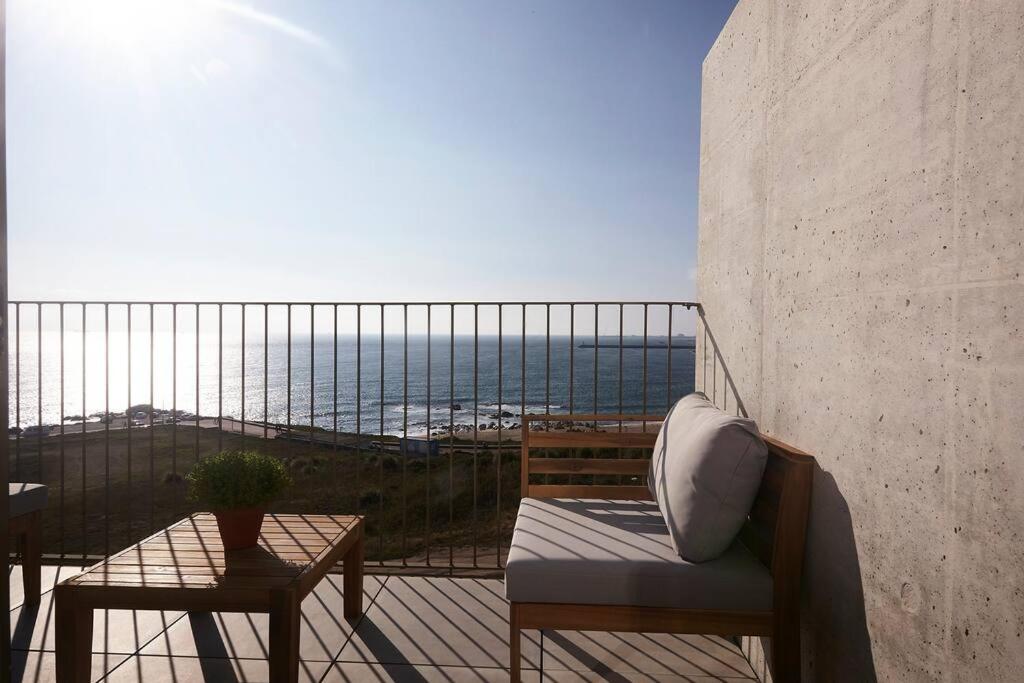 a balcony with a chair and a table and the ocean at Porto sunset suite in Vila Nova de Gaia