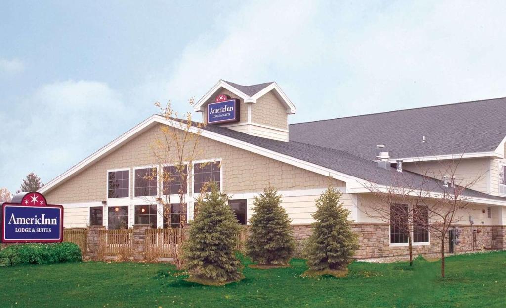 a building with a sign on top of it at AmericInn by Wyndham Charlevoix in Charlevoix