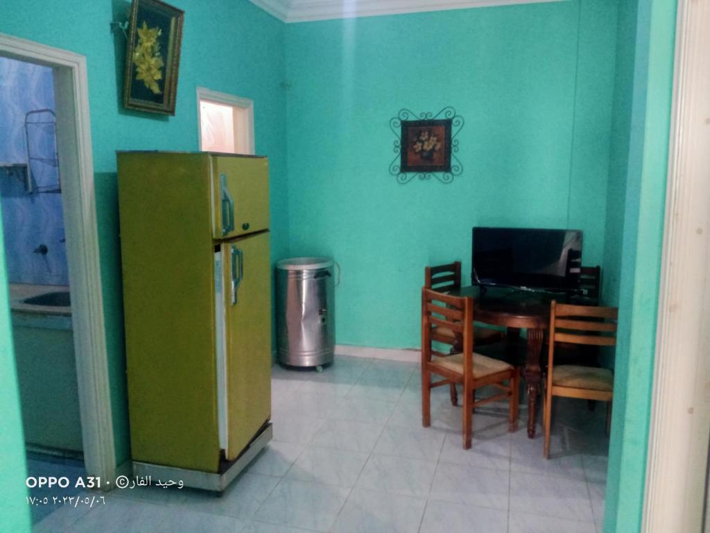 een keuken met een koelkast en een tafel met stoelen bij رأس البر in Ras El Bar
