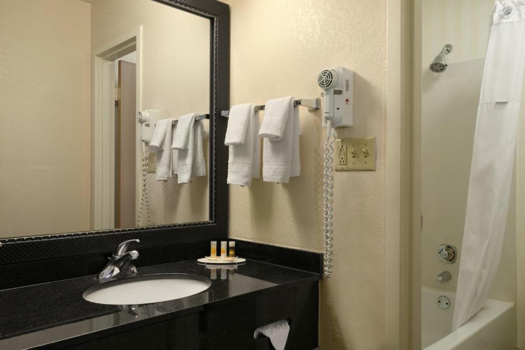 a bathroom with a sink and a mirror at Days Inn by Wyndham Chattanooga/Hamilton Place in Chattanooga