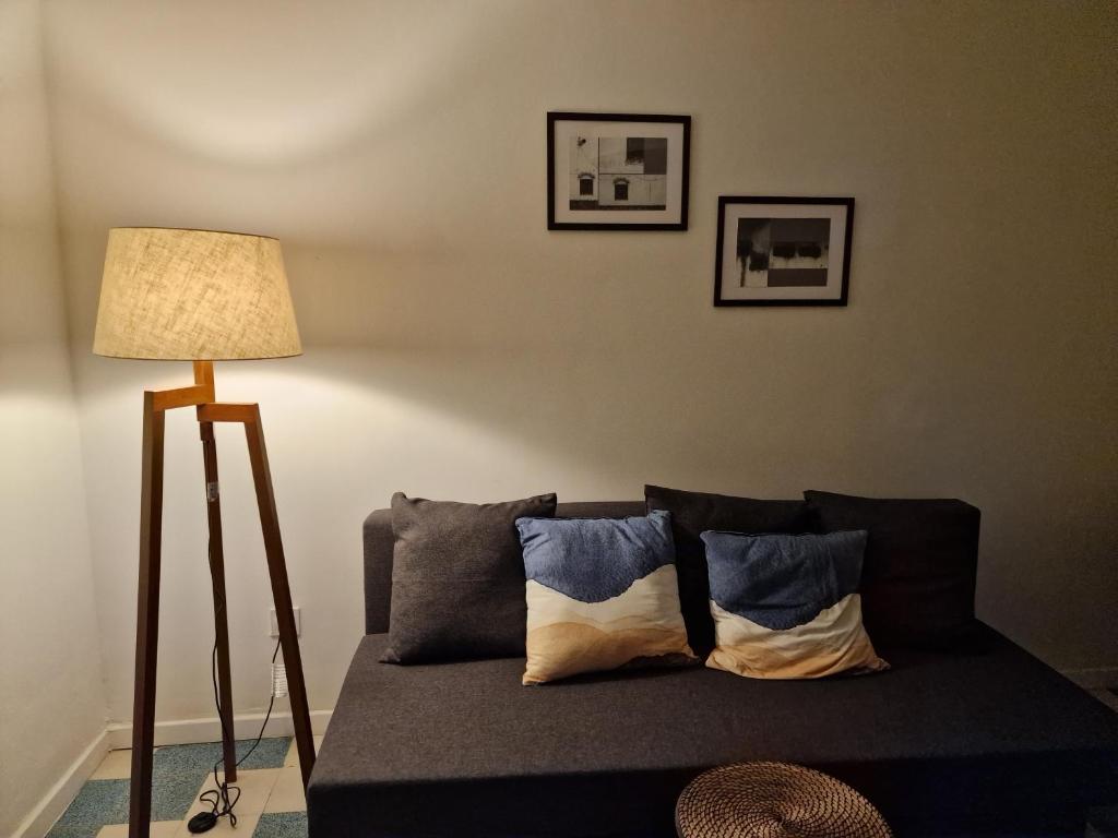 a living room with a couch and a lamp at maison PING ,en face des arènes in Béziers
