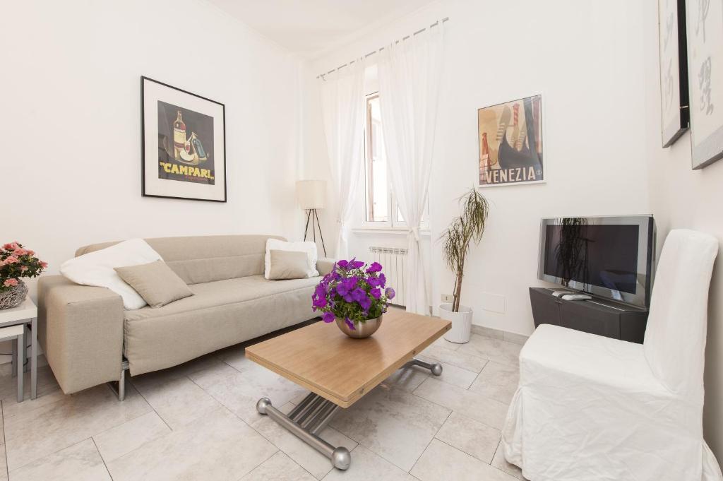 ein Wohnzimmer mit einem Sofa und einem Tisch in der Unterkunft Foscolo al 24 in Rom