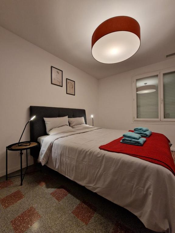 a bedroom with a large bed with a red blanket at maison PING ,en face des arènes in Béziers