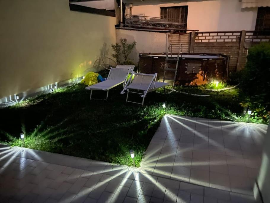 a backyard with two lawn chairs and lights at Indomabile Home Como in Cantù