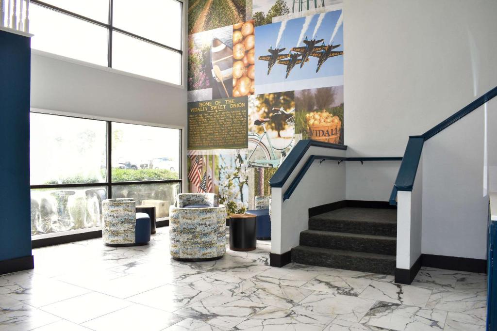 a lobby of a building with stairs and windows at Clarion Pointe Vidalia - Lyons West in Vidalia