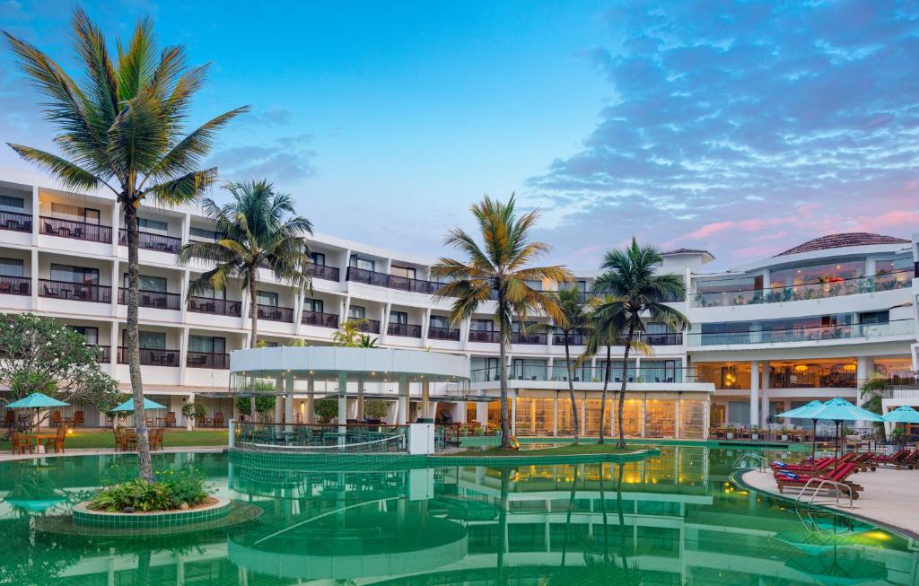 un hotel con piscina frente a un edificio en Occidental Eden Beruwala, en Bentota