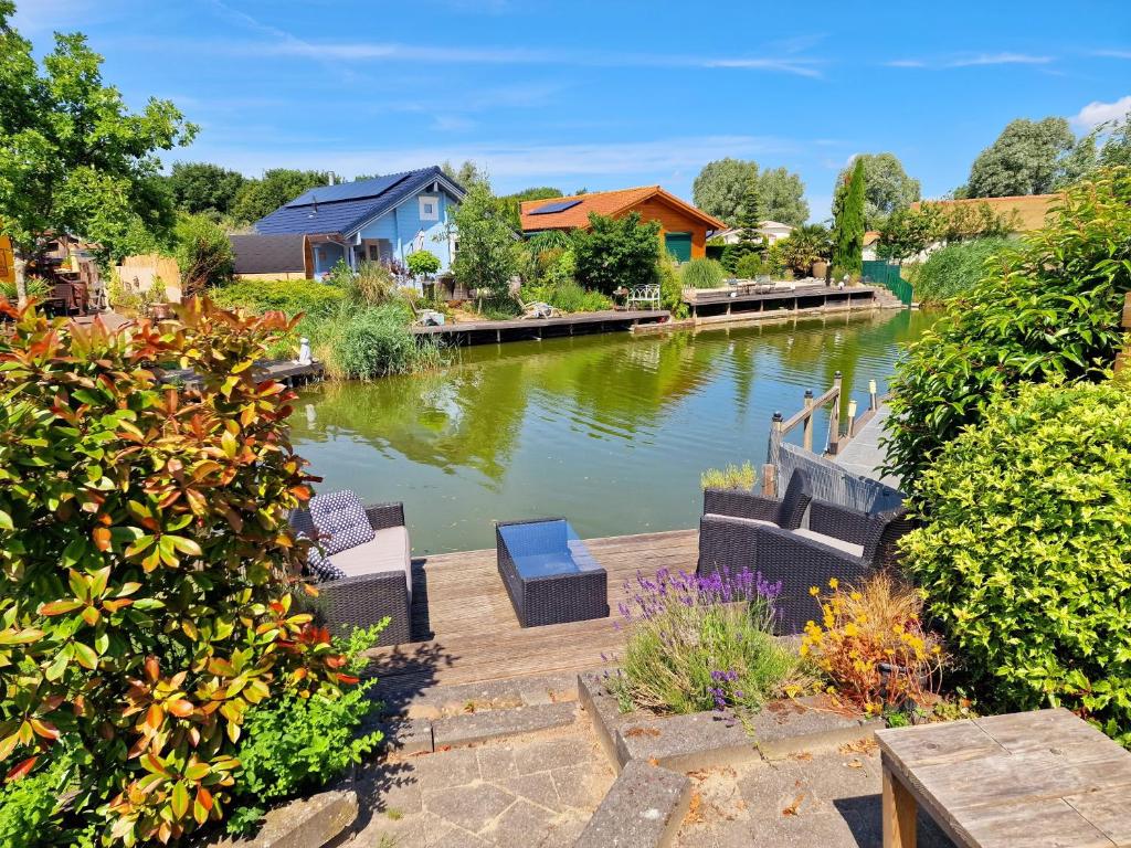 シント・アナラントにあるDe Poort van Zeeland aan het water met jacuzziの川の景色を望むベンチと家屋