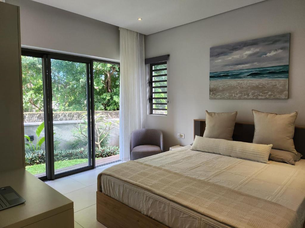 a bedroom with a bed and a view of the ocean at Soleia 3 in Mauritius in Grand-Baie
